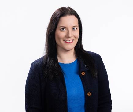 A person with dark hair and blue eyes wearing a blue knit sweater and a dark blue blazer.
AI-generated content may be incorrect.